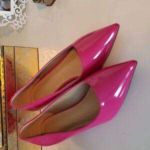 Pink patent leather kitten heel pumps.